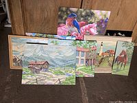 Lot of 7 vintage paint by number paintings showing different subjects including nature scenes, animals, and rustic buildings.