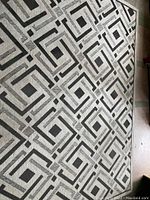 Full view of the rectangular outdoor carpet showing the geometric pattern and color scheme.