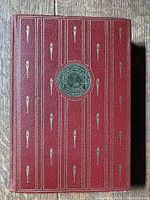 Front cover of the book, displaying red leather with gold torch motifs and central Smithsonian emblem.