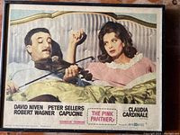 Full view of framed poster showing actors in bed scene with violin, cast names, and Pink Panther logo