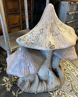 Front angle of the vintage concrete mushroom garden statue showing detailed caps and stems with weathered surface.