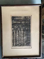 Framed etching showcasing architectural details of Notre Dame de Paris, with gothic arches and balustrades visible.
