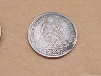 Close-up image of the 1886 seated Liberty quarter coin showing the seated figure of Liberty and the date '1886' at the bottom.