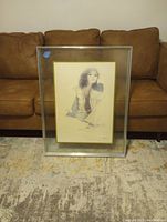 Full view of the framed lithograph titled 'Summer Mood' by Christine Rosamond, showing the entire artwork and frame against a couch background.