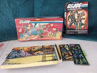 GI Joe collector case and Colorforms playset box with sticker sheets laid out in front