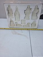 Photo showing the nativity set figures inside the original styrofoam packaging with a measuring tape for scale.