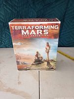 Photo of the front box of Terraforming Mars Ares Expedition board game showing astronauts on Mars and game title.