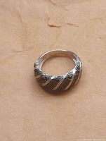 Top view of sterling silver ring showing textured black diagonal stripes with polished silver stripes.