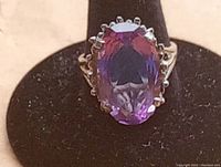 Front view showing the large oval purple gemstone with detailed prong setting on the sterling silver ring.