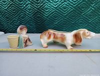 Photo showing both pottery planters - dachshund dog planter and girl camper planter with measurement tape for size reference.