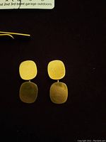 Front view of two cushion-shape cufflink panels on black background