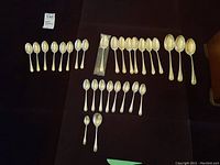 Full set of 29 spoons arranged on black cloth