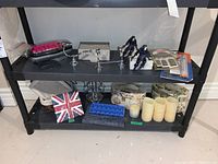 Shelf with artificial cream candles, floral boxes, horse figurines, and other small items
