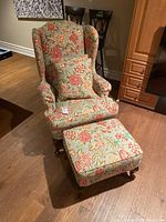 Front perspective view of chair and ottoman showing upholstery pattern and overall design.