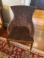 Front view of brown velvet armchair showing high back and wooden legs