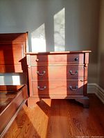 Front and side view of solid cherry wood dresser showing three drawers and brass hardware with minor scratches.