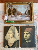 Photo showing the original framed winter landscape painting with two Renaissance style portrait prints below it, laid flat on a surface.