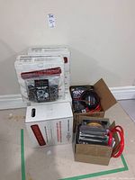 Photo showing multiple boxes and packages of RimSkins alloy wheel rim protectors on the floor against a wall.