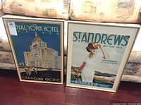 Two framed vintage Canadian travel posters side by side on floor showing The Royal York Hotel Toronto and St. Andrews By-The-Sea New Brunswick Canada.