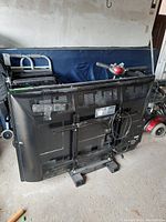 Rear view of Panasonic plasma TV showing remote control taped to the back along with some surroundings.