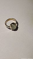 Photo of a silver ring with oval catseye quartz gemstone on a flat surface.