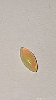 Close-up photo of marquise-shaped Ethiopian opal showing translucent body and flashes of color.