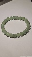 Natural green aventurine bracelet laid flat showing round beads.