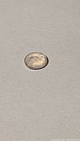 Oval cut natural rose quartz gemstone laying on a flat surface showcasing its soft pink hue and high clarity.