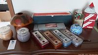 Photo showing assortment of candles, wax melts, candle holders and a Christmas-themed item on a wooden table.
