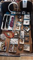 Overview of the full lot showing various jewelry items arranged in boxes and trays.