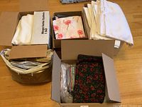 Four boxes filled with assorted fabric pieces in various patterns and colors.