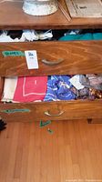 Top dresser drawer labeled 'GLOVES' showing folded gloves in various colors and styles