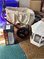 Photo showing Botanical small hand cart with beige fabric bag and black wheels, boxed Bug Blaster insect killer next to it, on carpet.
