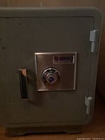 Front view of a gray metal combination safe with Sentry branding and dial lock.