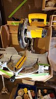 Top view of DeWalt miter saw showing blade, rotating base, and yellow handle.