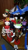 Photo showing various nutcracker figures including a character nutcracker, a Minnie Mouse figurine, and a wooden decorated Christmas tree.