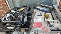 Dremel rotary saw with router attachment inside black plastic case showing tool and some accessories