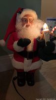 Front view of the animated Santa Claus figure with lit candle and visible motion features.