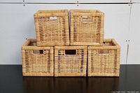 Five rectangular wicker baskets arranged in two rows showing front and top views, highlighting cut-out handles and woven texture.