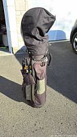Image of black and beige golf bag standing upright with head cover.