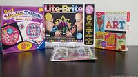 Photo showing three boxed activity kits: Lite-Brite, String Art, and Mandala Designer.