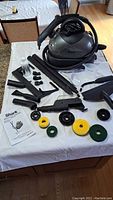 Full set of Shark steam cleaner and all attachments laid out on a table showing multiple accessories including brushes, extension tubes, nozzles, and instructions.