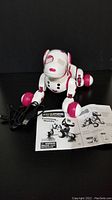 Zoomer robot puppy toy showing front with charging cable and training guide placed in front