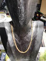 Front view of chain draped on black display bust showing full length and link pattern