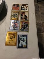 Eight Wayne Gretzky NHL hockey cards arranged in two columns on a table, all in plastic protective cases, showing different designs and uniforms.