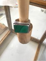 Front view of the sterling silver ring with green malachite stone mounted on a wooden ring sizer, showing rectangular shape and stone details.
