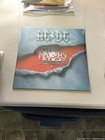 Front cover of sealed AC/DC The Razors Edge vinyl LP showing band logo and album title.
