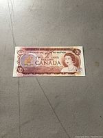 Full front view of the 1974 Canadian two dollar note on a neutral surface.