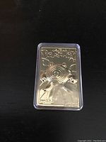 Front view of the gold plated Pokémon Poliwhirl card in clear protective case showing embossed Poliwhirl image and Pokémon logo.