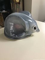 Side view showing the mouse bank's large ears, smooth gray ceramic surface, and detailed eye.